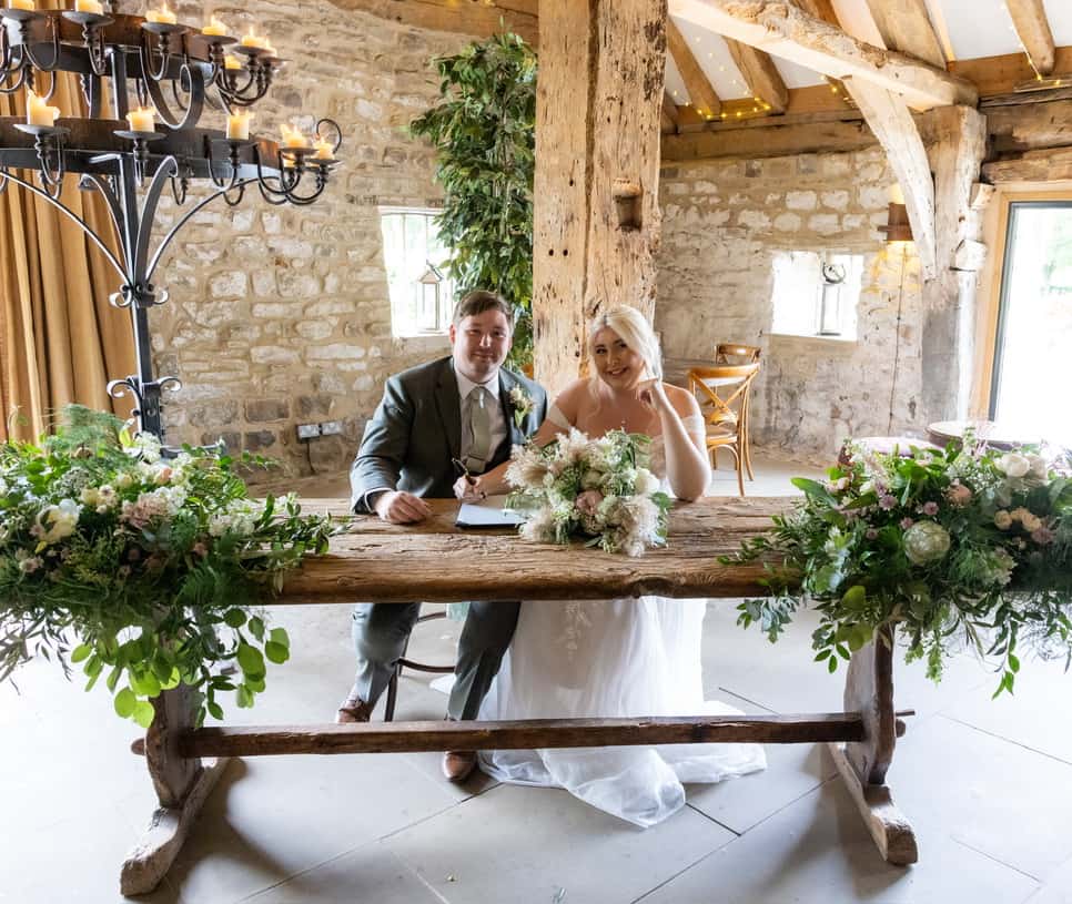 Liam and Megan signing their marriage certificate at their wedding